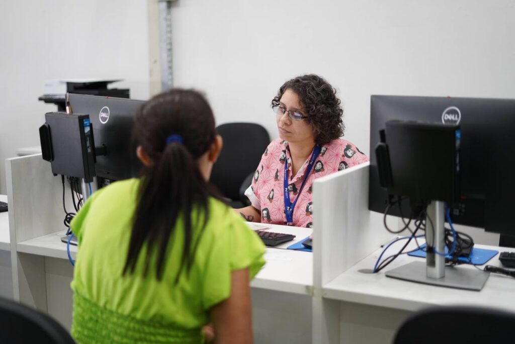 Mulher de verde é atendida por mulher da SETEMP em busca de emprego